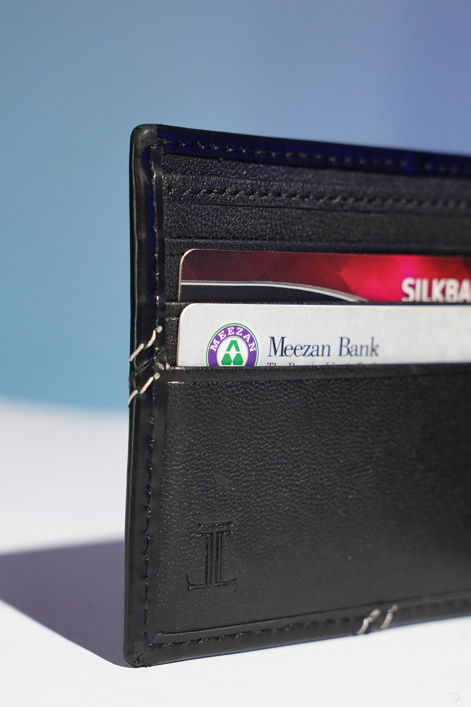 Mens leather bifold wallet in black colour with white contrast stich and metallic hardware by JULKE