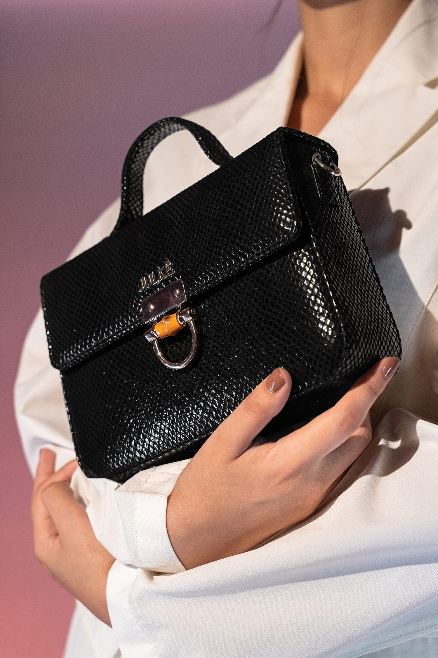 Women's leather top handle shoulder bag in black reptile texture with metal wood and metallic gold chain strap by JULKE