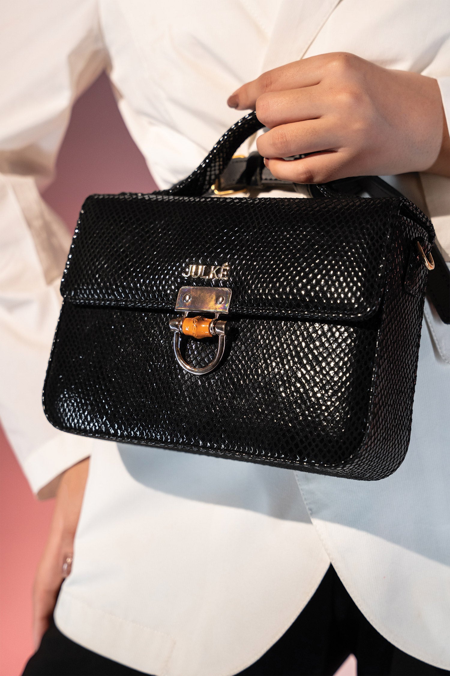 Women's leather top handle shoulder bag in black reptile texture with metal wood and metallic gold chain strap by JULKE