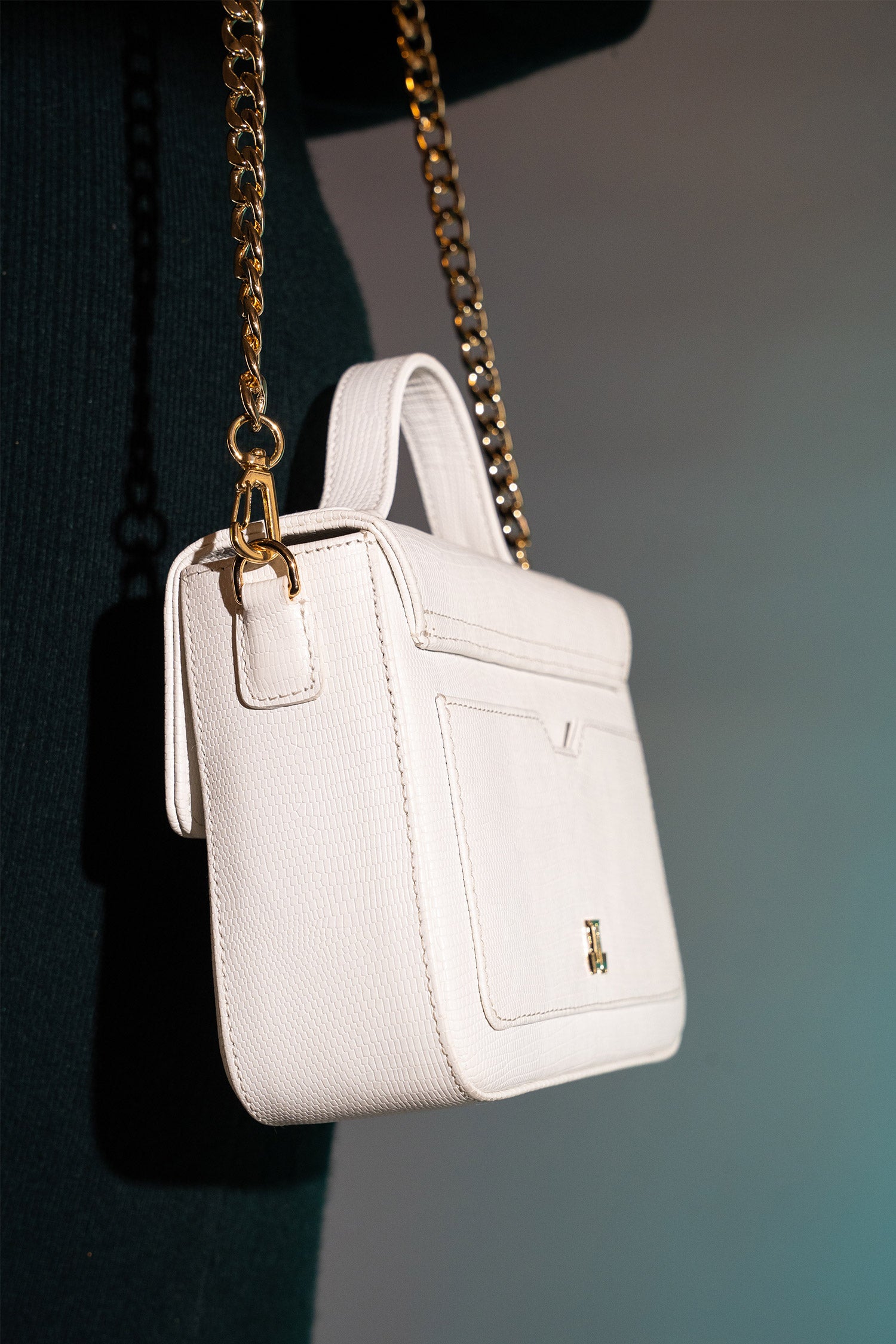 Women's leather top handle shoulder bag in white reptile texture with metal wood and metallic gold chain strap by JULKE