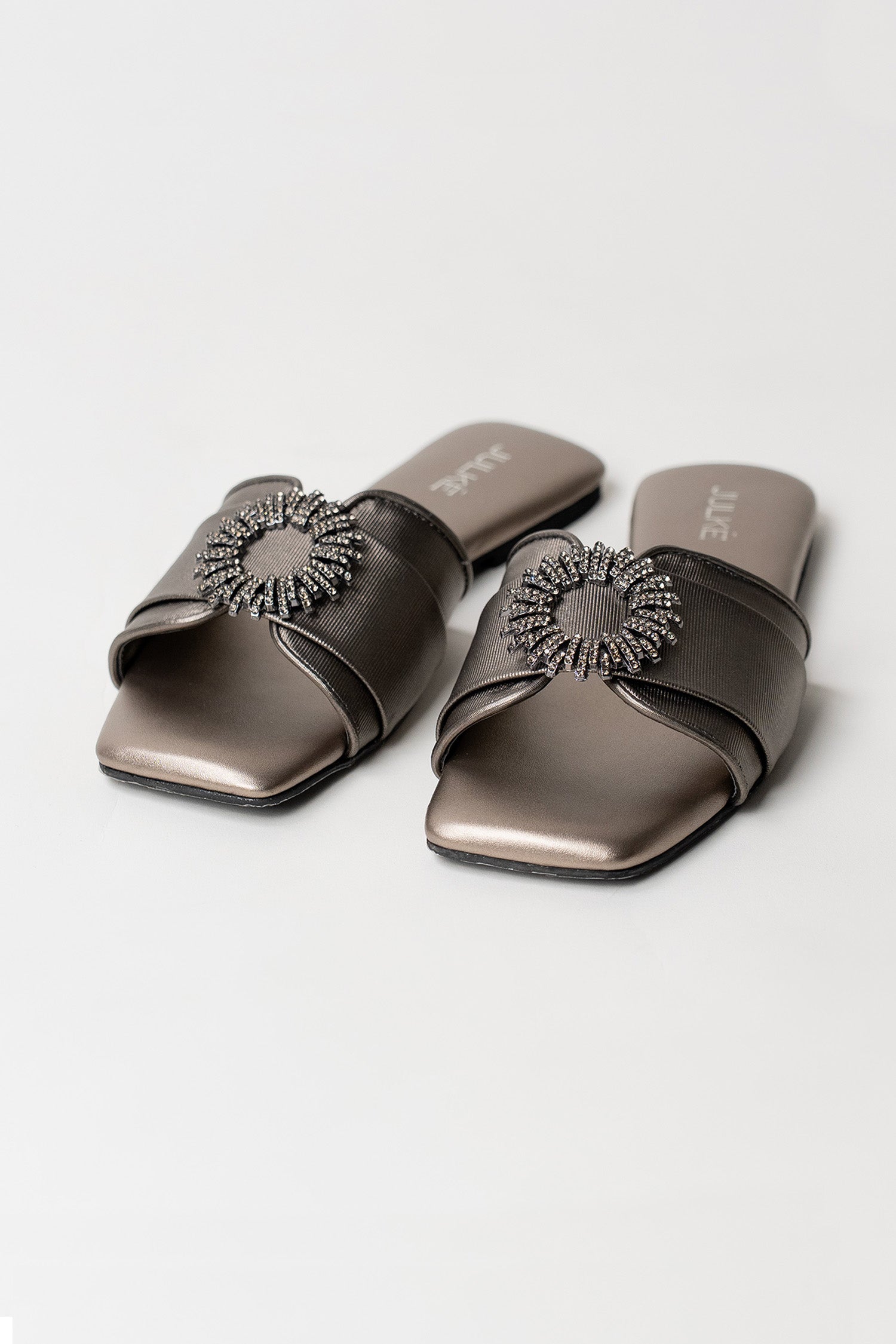 Women's festive leatherite flat shoes in gun metal colour with round silver diamante brooch and padded insock by JULKE.