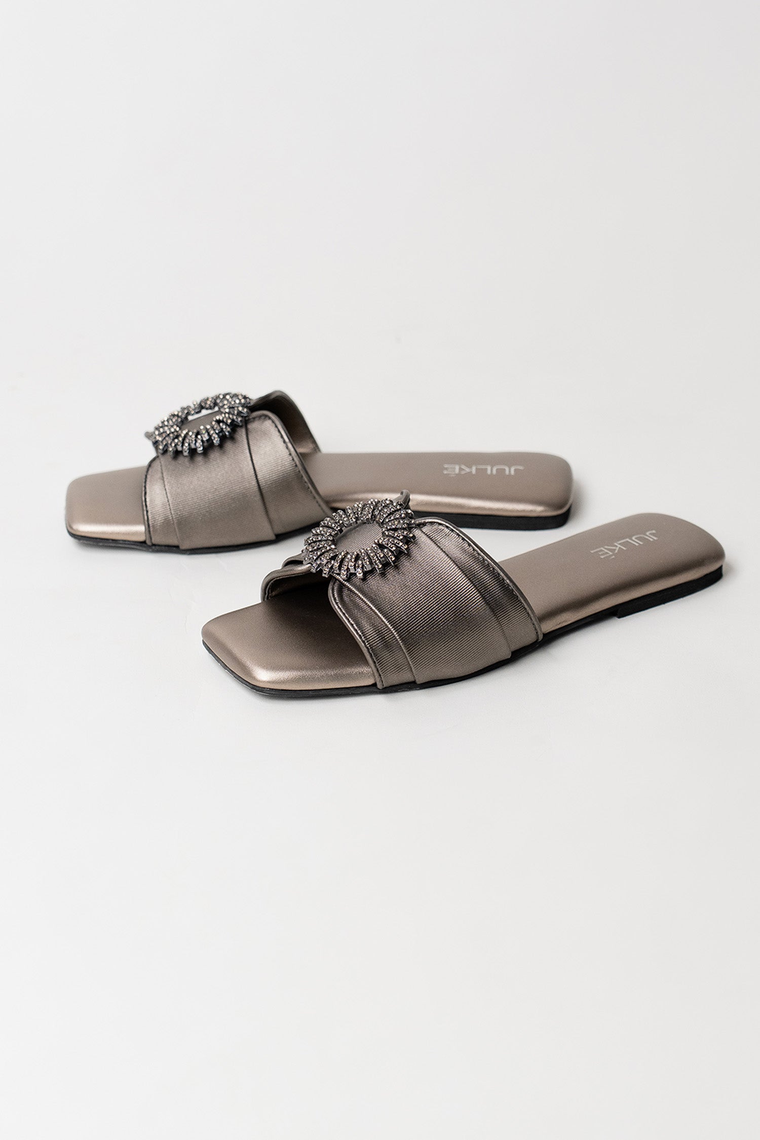 Women's festive leatherite flat shoes in gun metal colour with round silver diamante brooch and padded insock by JULKE.
