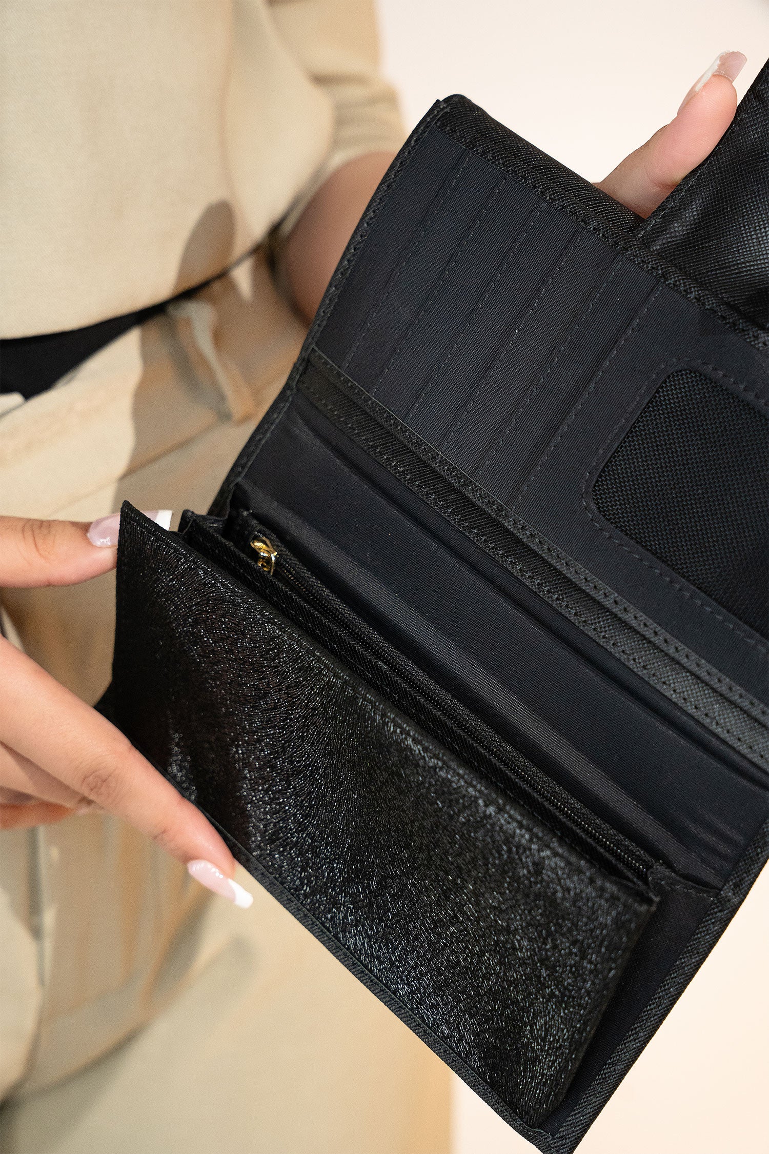 Women's leather long wallet in black colour in crosshatch texture with gold metal press button strap and extra pockets by JULKE.