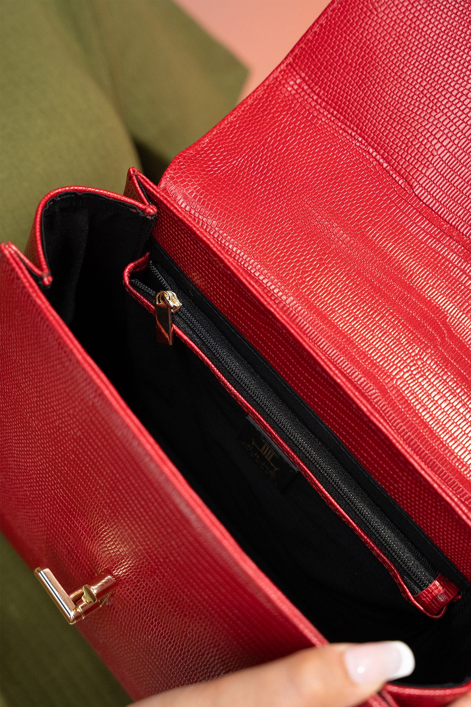 Women's reptile texture leather top handle bag in red colour with detachable shoulder strap and unique oval twist lock by JULKE.