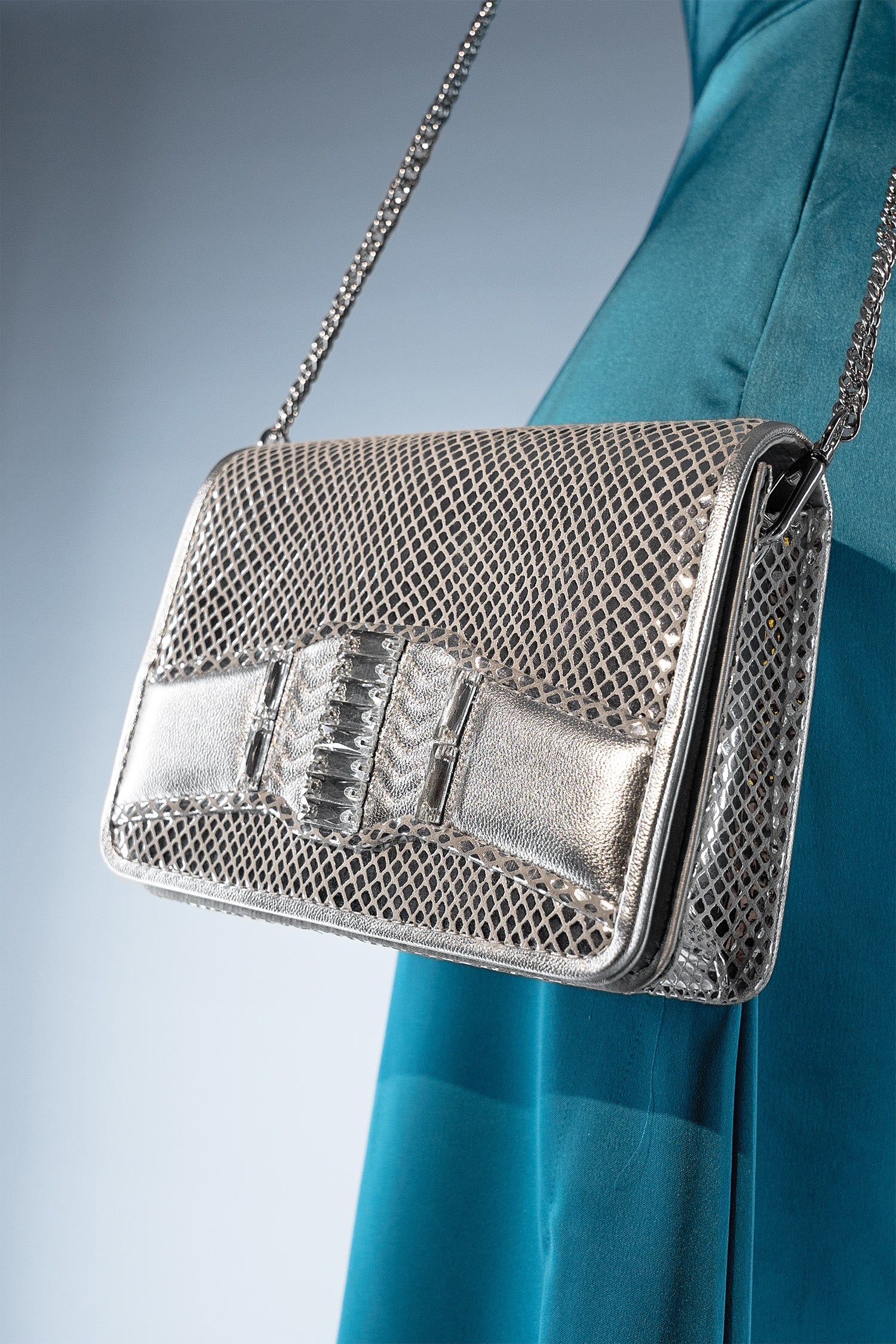 Women's leather reptile texture shoulder clutch bag in silver colour with rhinestones and detachable golden shoulder chain by JULKE.