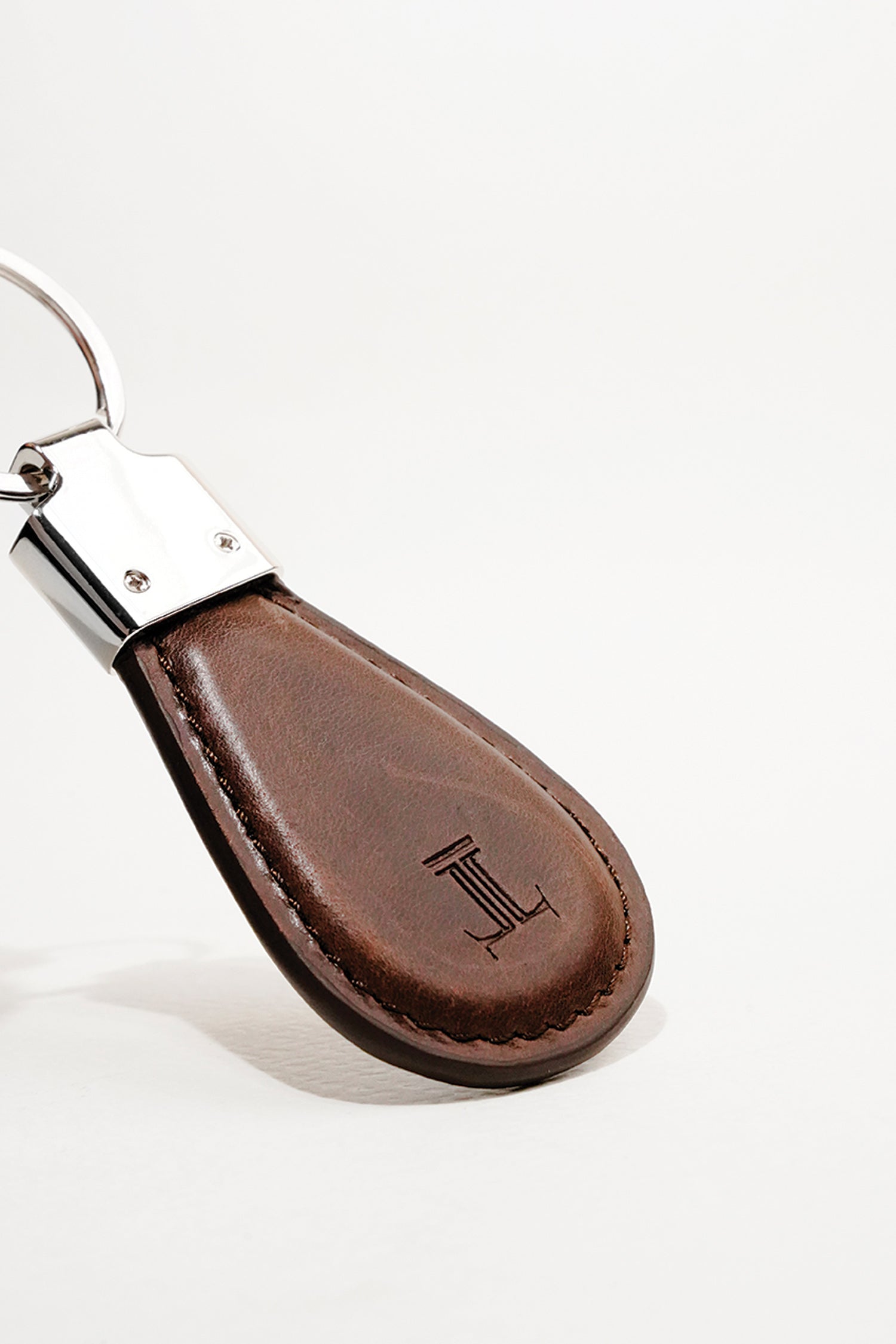 Leather key chain in dark brown colour in round shape and metal ring by JULKE
