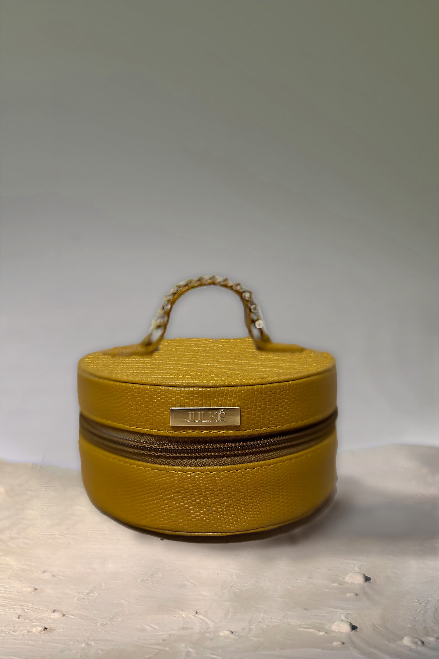 Women's leather round bag in mustard yellow colour for jewellery and accessories with top handle by JULKE
