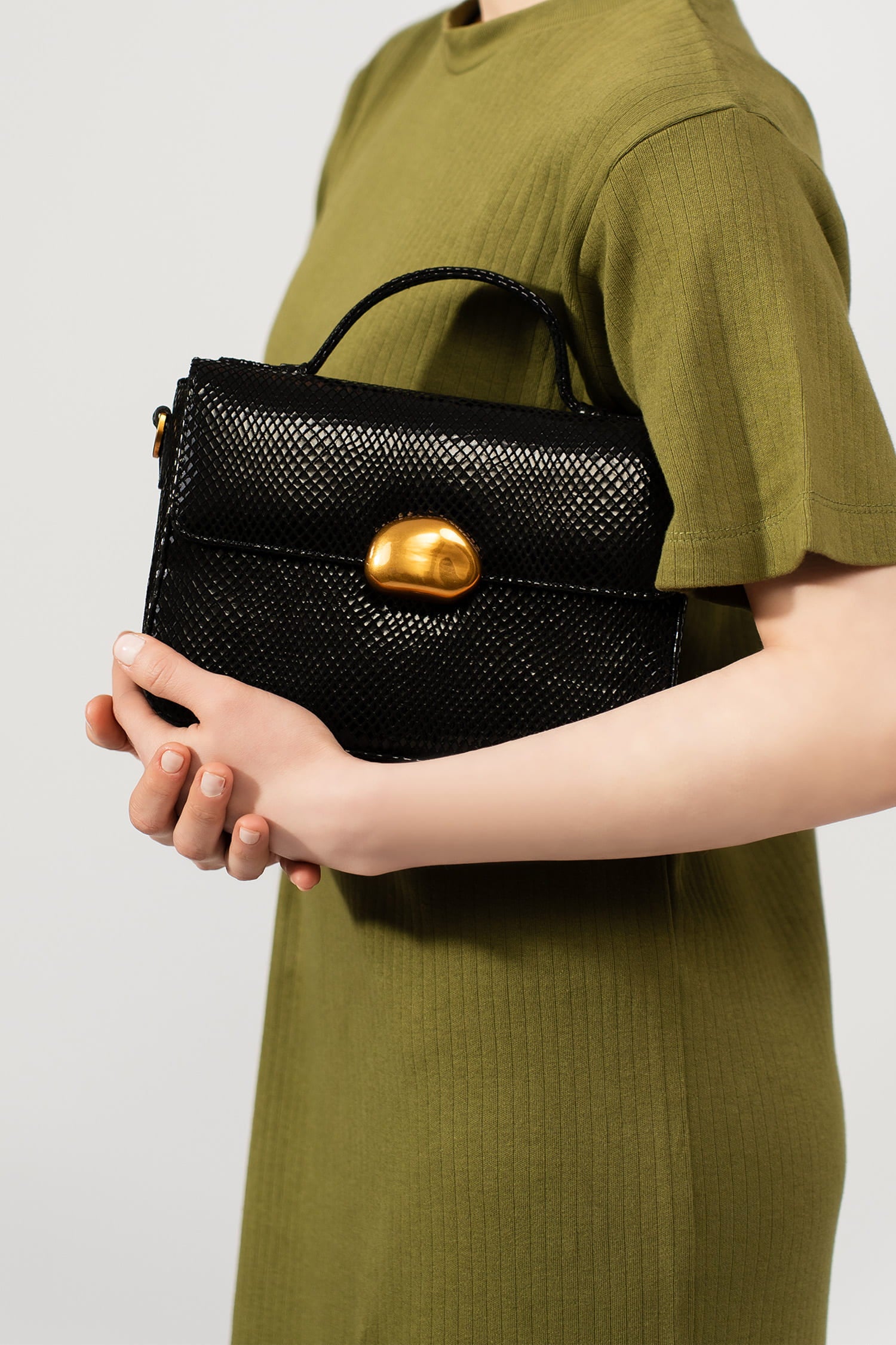 Womens leather top handle shoulder bag in glossy black reptile texture with unique golden metallic lock and metallic chain strap by JULKE.