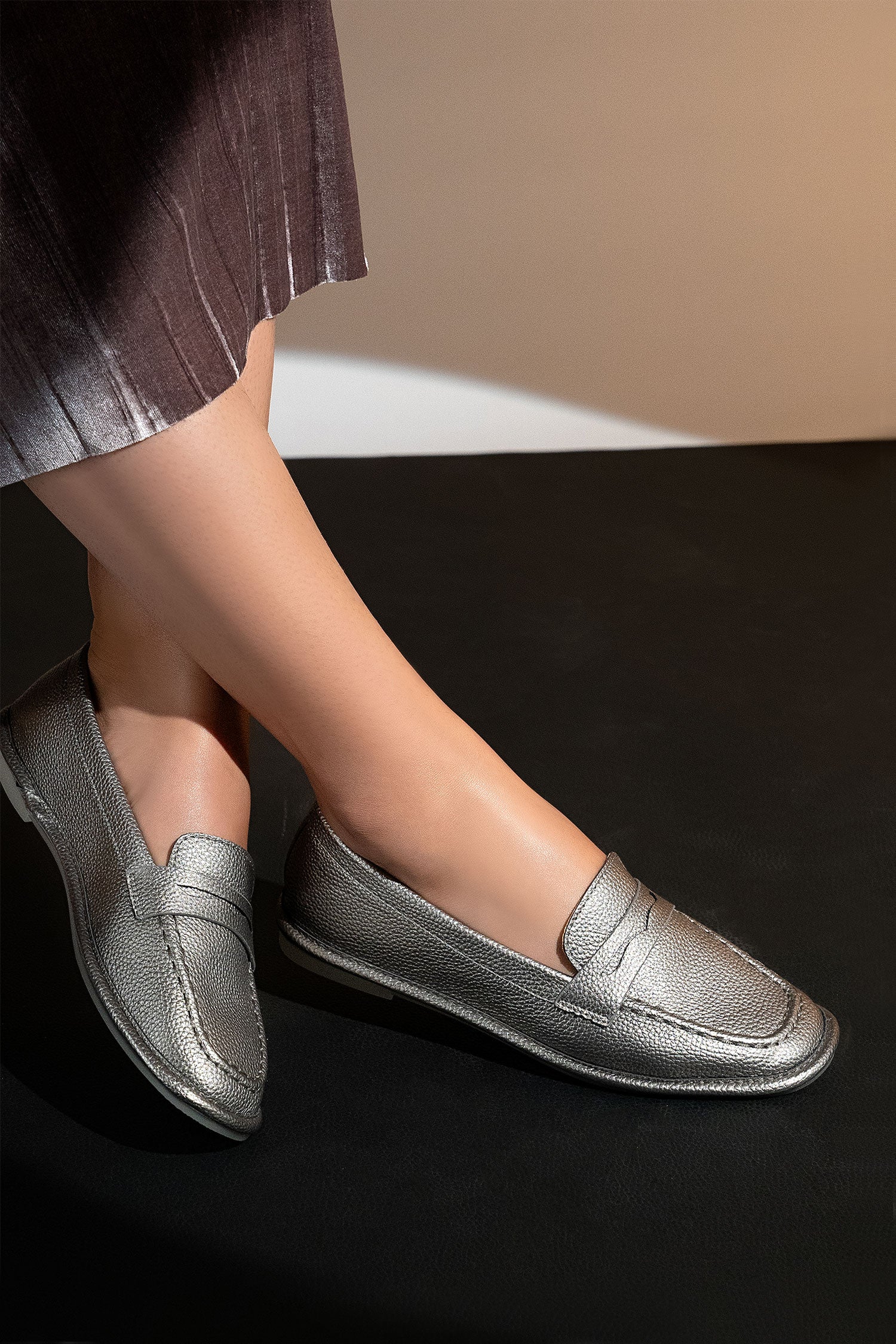 Women's flat moccasin style shoes in silver colour and leather texture with flexible transparent rubber sole and padded in-socks by JULKE.