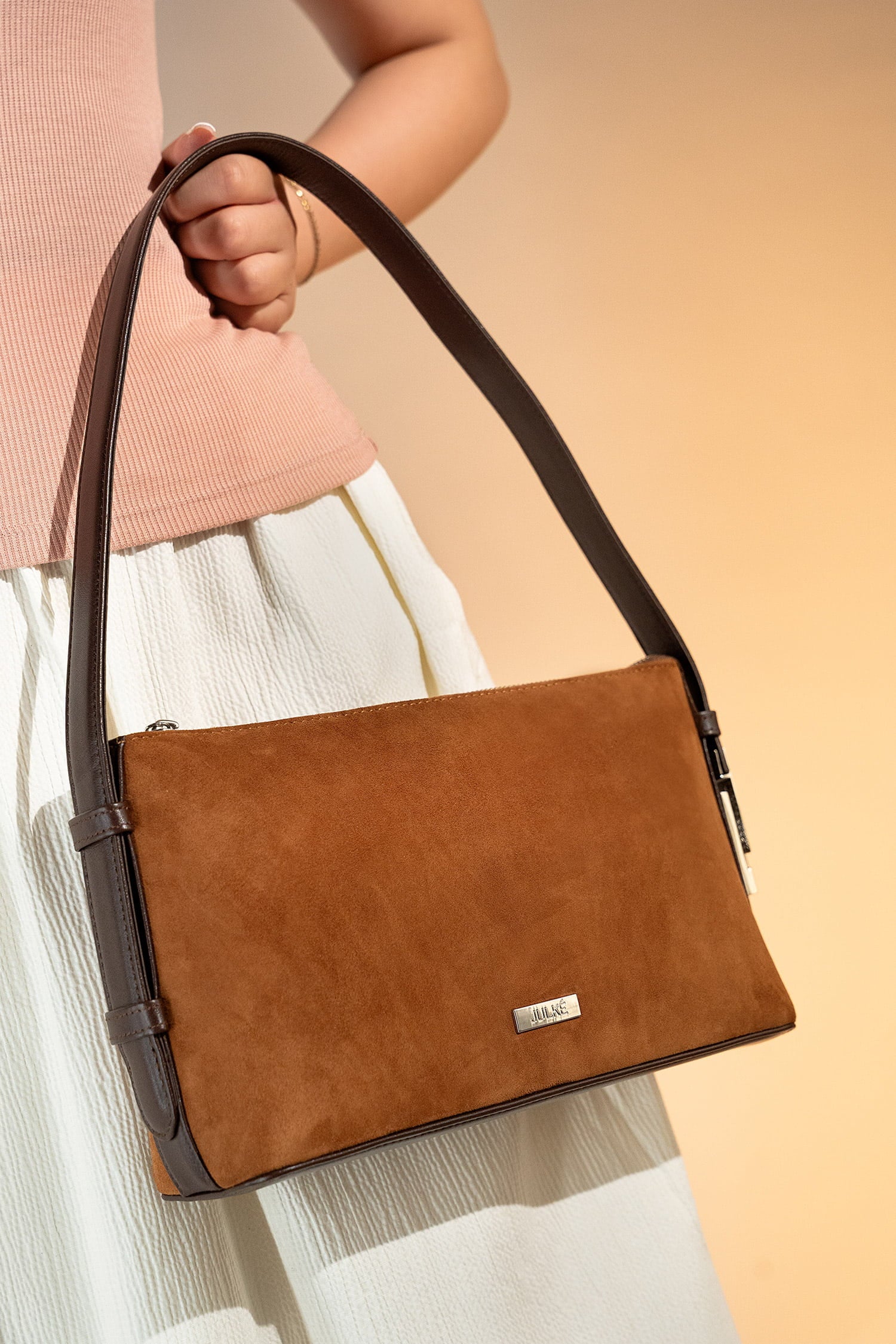 Women's suede leather mini shoulder bag in brown colour with contrast shoulder strap and metallic side lock by JULKE.