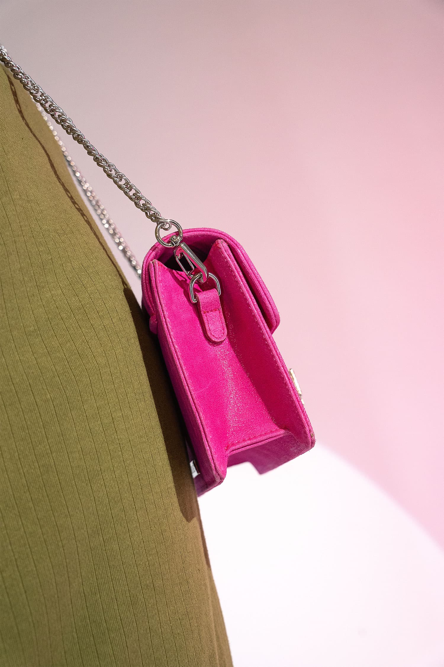 Women's suede leather clutch bag in shiny pink colour with satin pleated flap and geometric transparent rhinestone brooch by JULKE.