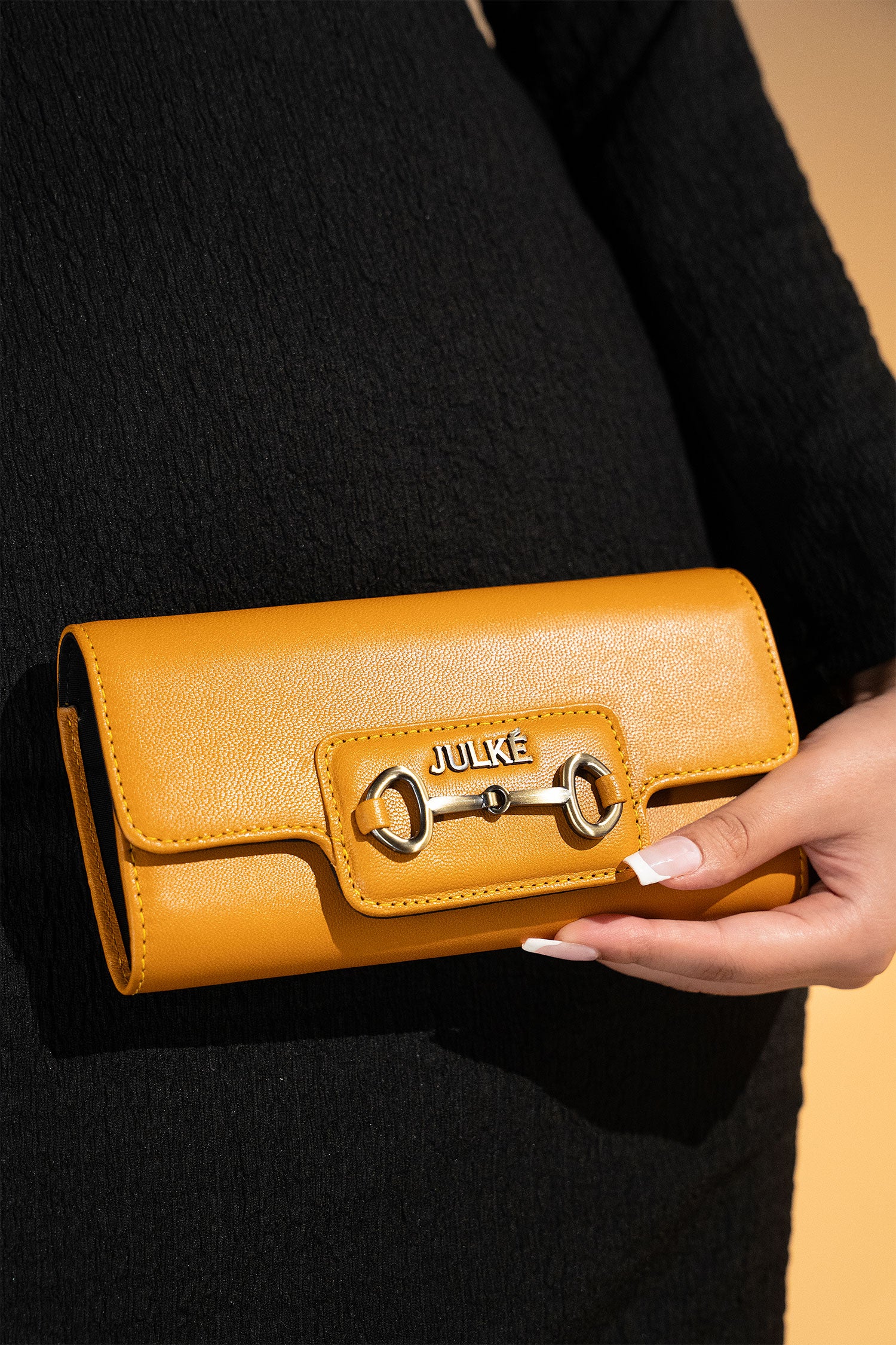 Women's leather long wallet in mustard yellow colour in envelope shape with long pockets and metallic horse-bit buckle and brand logo by JULKE.