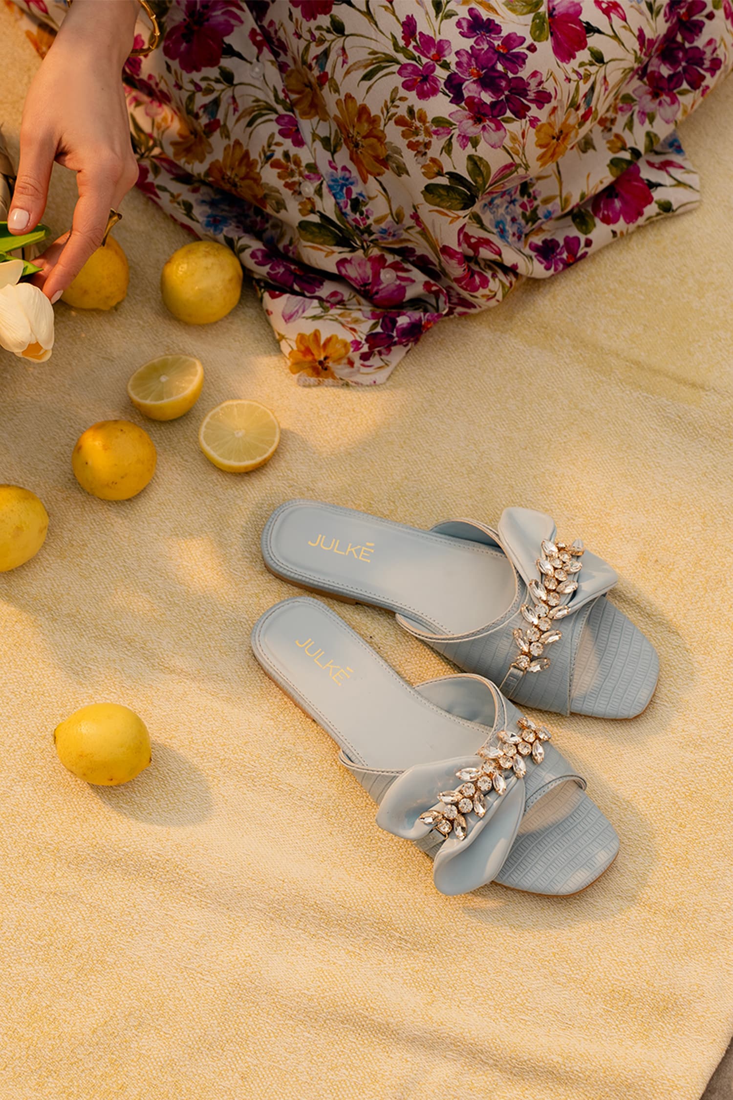 Womens flat slides in light blue colour with asymmetric bow strap and floral diamante chain ornament by JULKE.