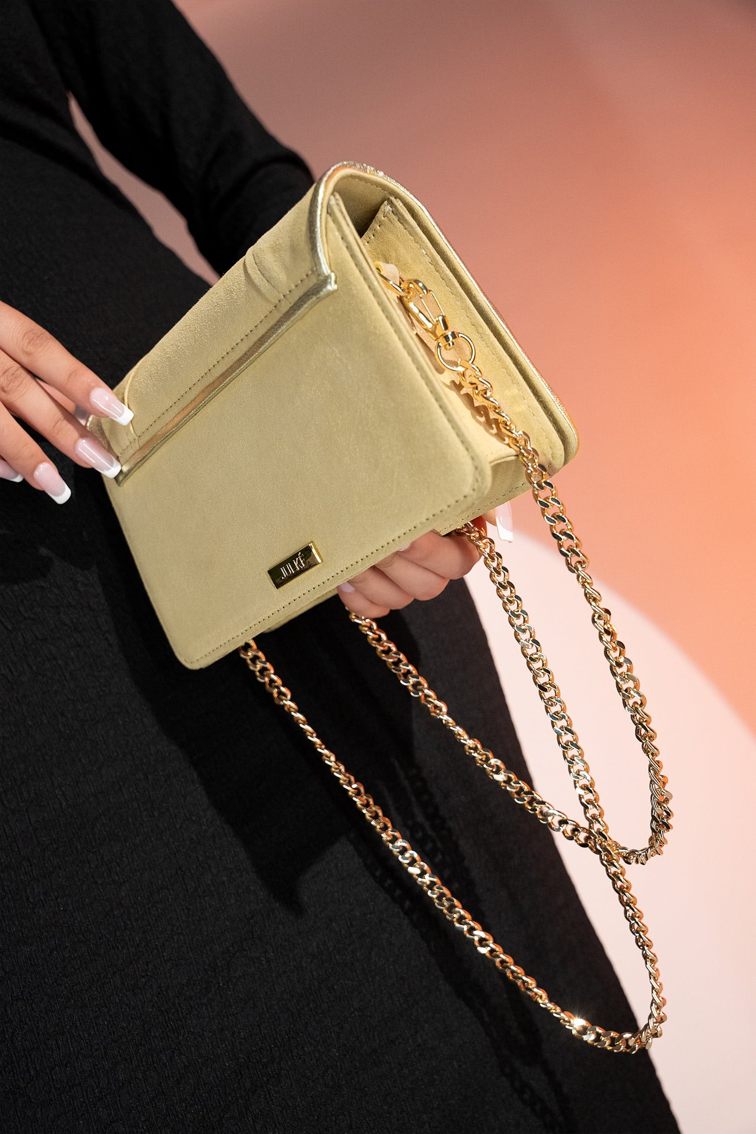 Women's leather shoulder clutch bag in light gold colour with satin piping and rhinestone brooch by JULKE. 