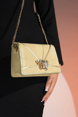 Womens leather shoulder clutch bag in light gold colour with satin piping and rhinestone brooch by JULKE. 