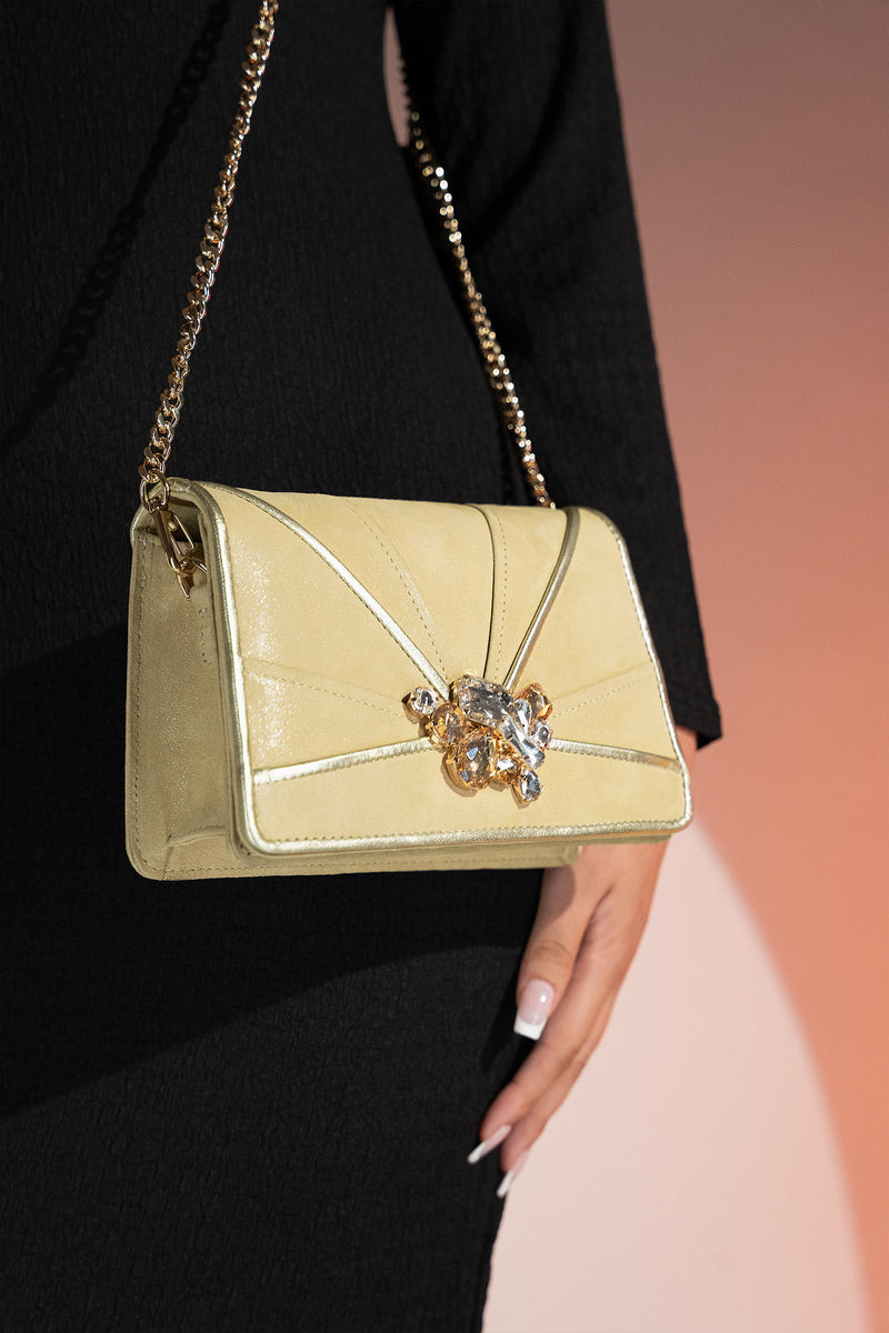 Womens leather shoulder clutch bag in light gold colour with satin piping and rhinestone brooch by JULKE. 