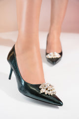 Women's high heel pointed toe pumps in dark green colour with shiny reptile texture and flower shaped white rhinestone brooch by JULKE