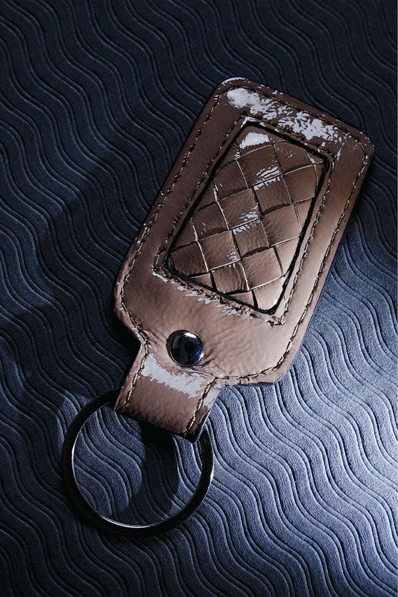 Leather key chain in grey brown colour with weaving and metal ring by JULKE
