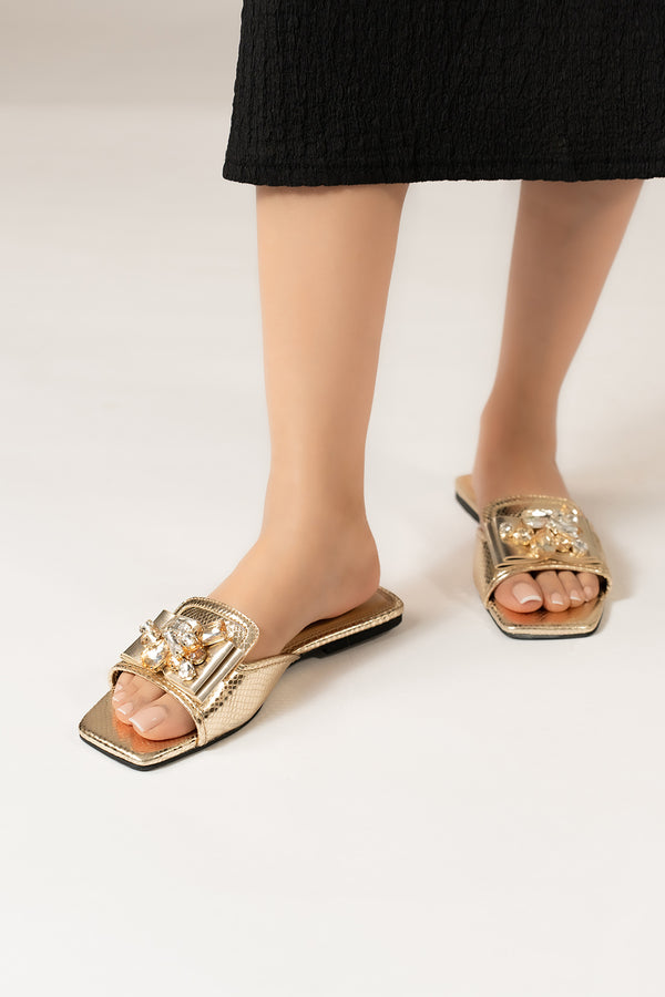 Womens flat slides in gold colour with shiny foilded reptile texture and golden asymmetric rhinestone brooch by JULKE.