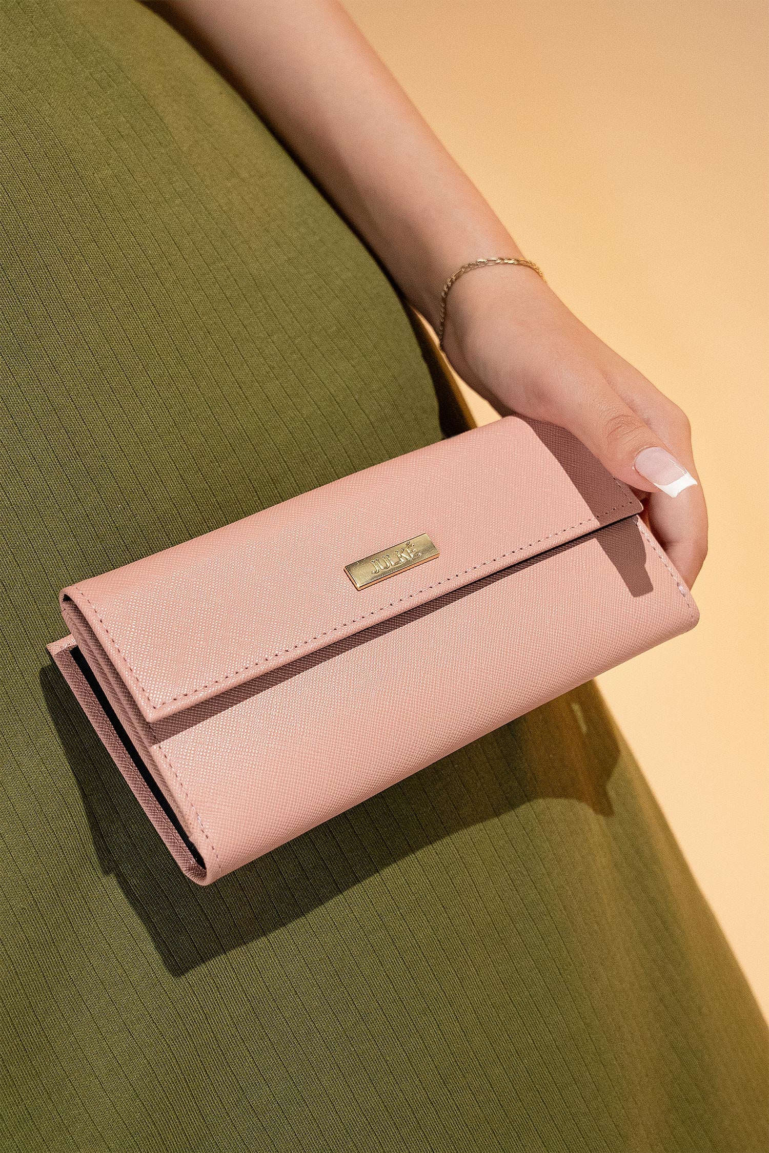 Women's leather long wallet in light pink colour in crosshatch texture with gold metal press button strap and extra pockets by JULKE. 