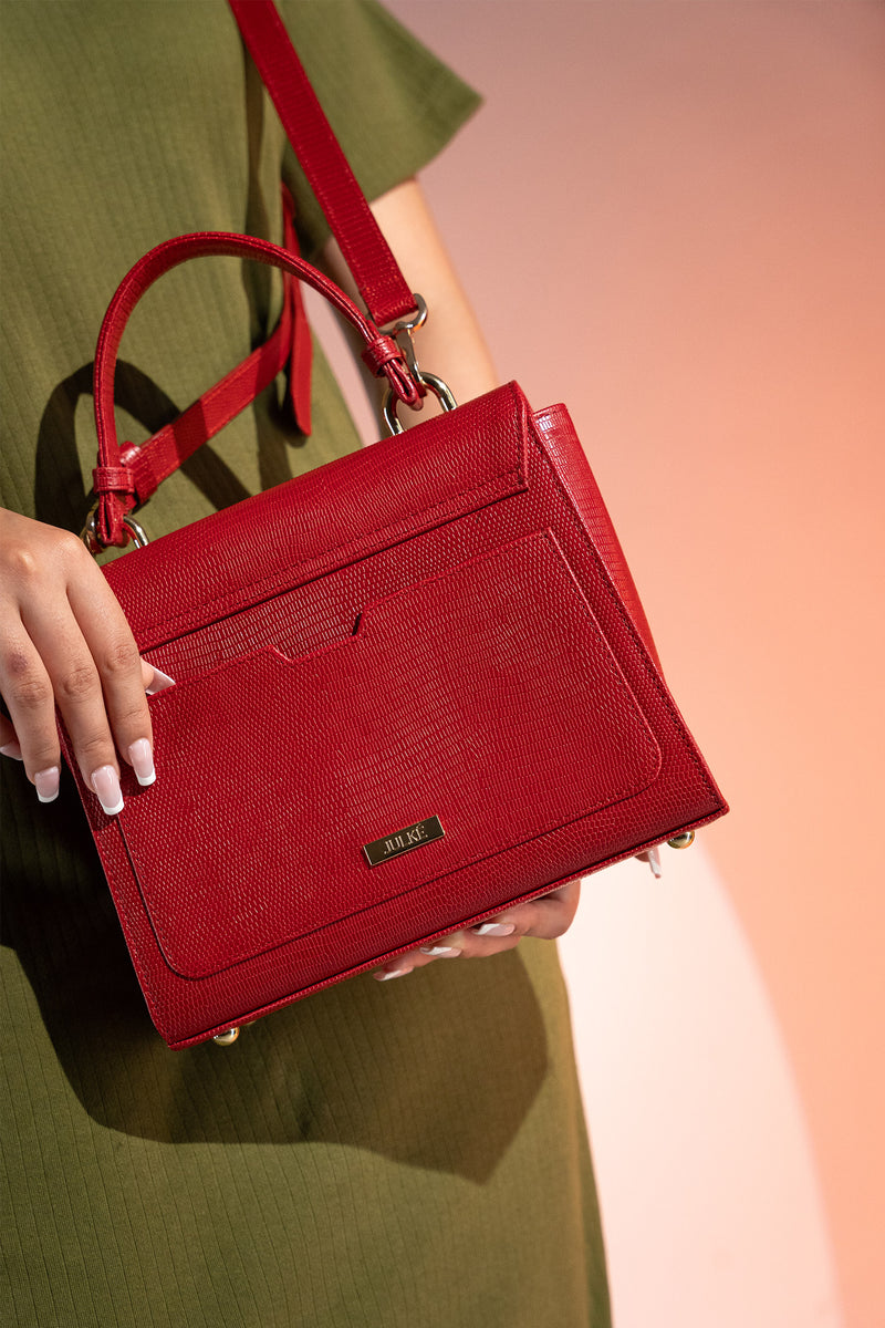 Women's reptile texture leather top handle bag in red colour with detachable shoulder strap and unique oval twist lock by JULKE. 