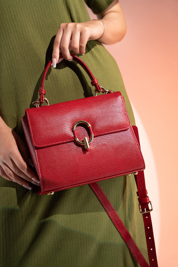 Women's reptile texture leather top handle bag in red colour with detachable shoulder strap and unique oval twist lock by JULKE. 