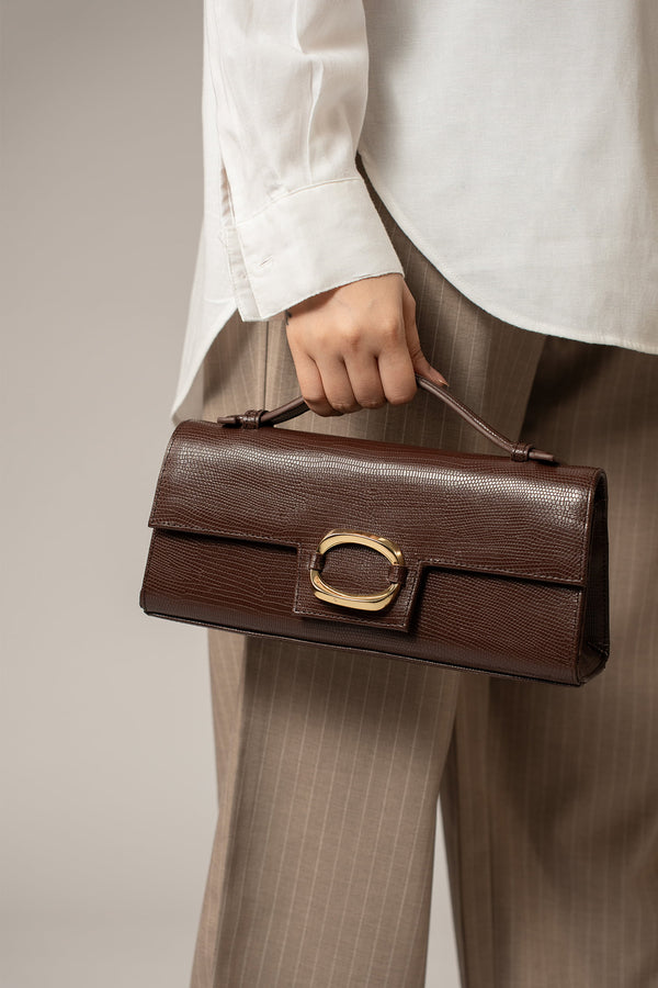 Womens leather top handle shoulder bag in dark brown colour with reptile texture and oval gold buckle by JULKE. 