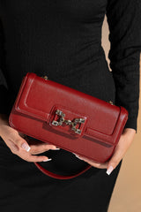 Women's leather shoulder bag in maroon colour in rectangular shape with gold horse-bit buckle of transparent circle rhinestones and short chain and leather shoulder strap by JULKE