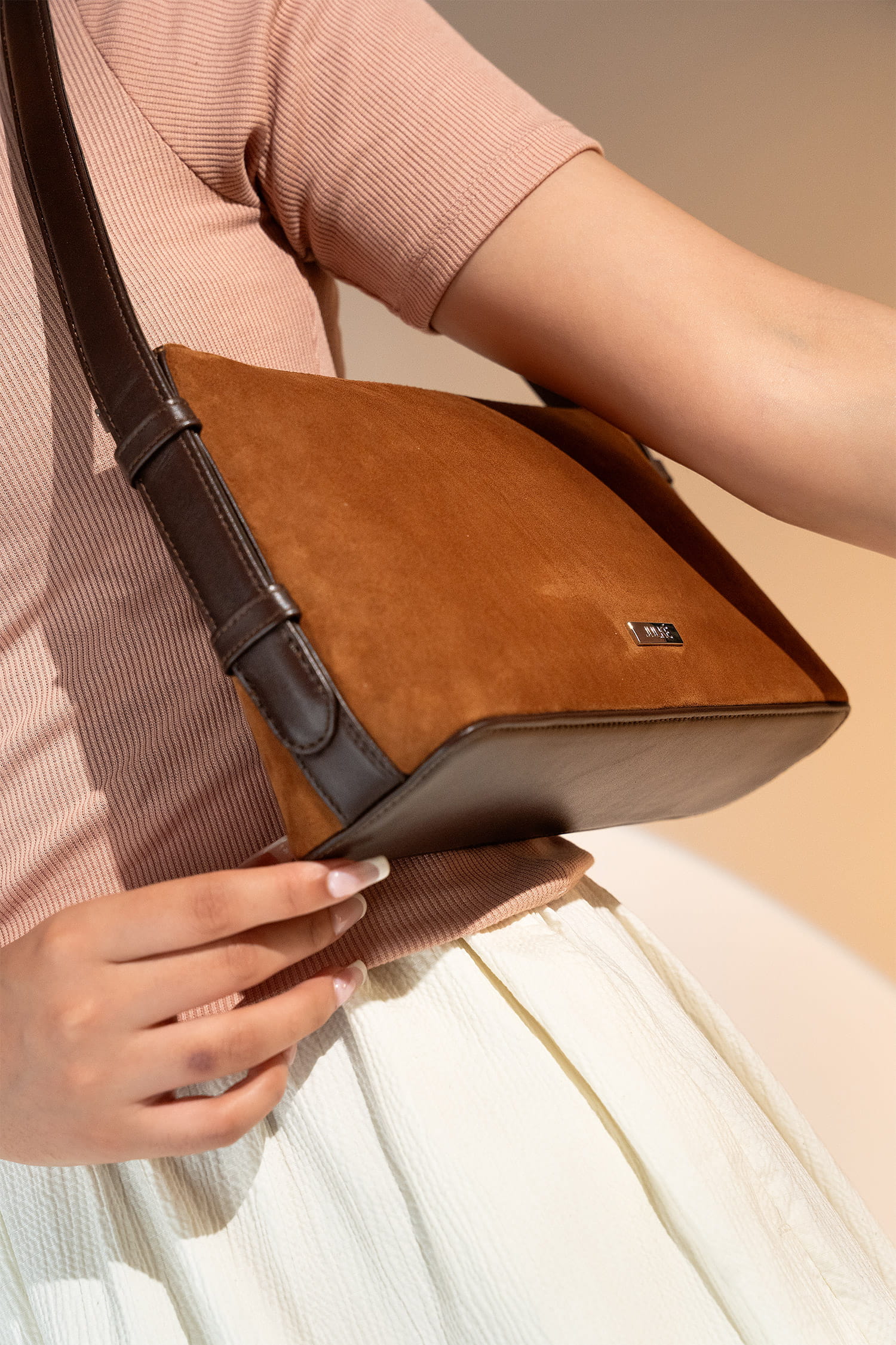 Women's suede leather mini shoulder bag in brown colour with contrast shoulder strap and metallic side lock by JULKE.