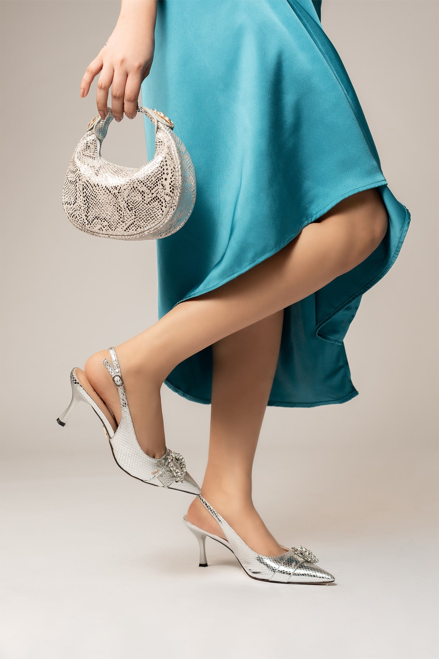 Womens slingback pointed toe heels in silver colour with metallic reptile texture and diamante buckle and matching leathe mini bag by JULKE. 