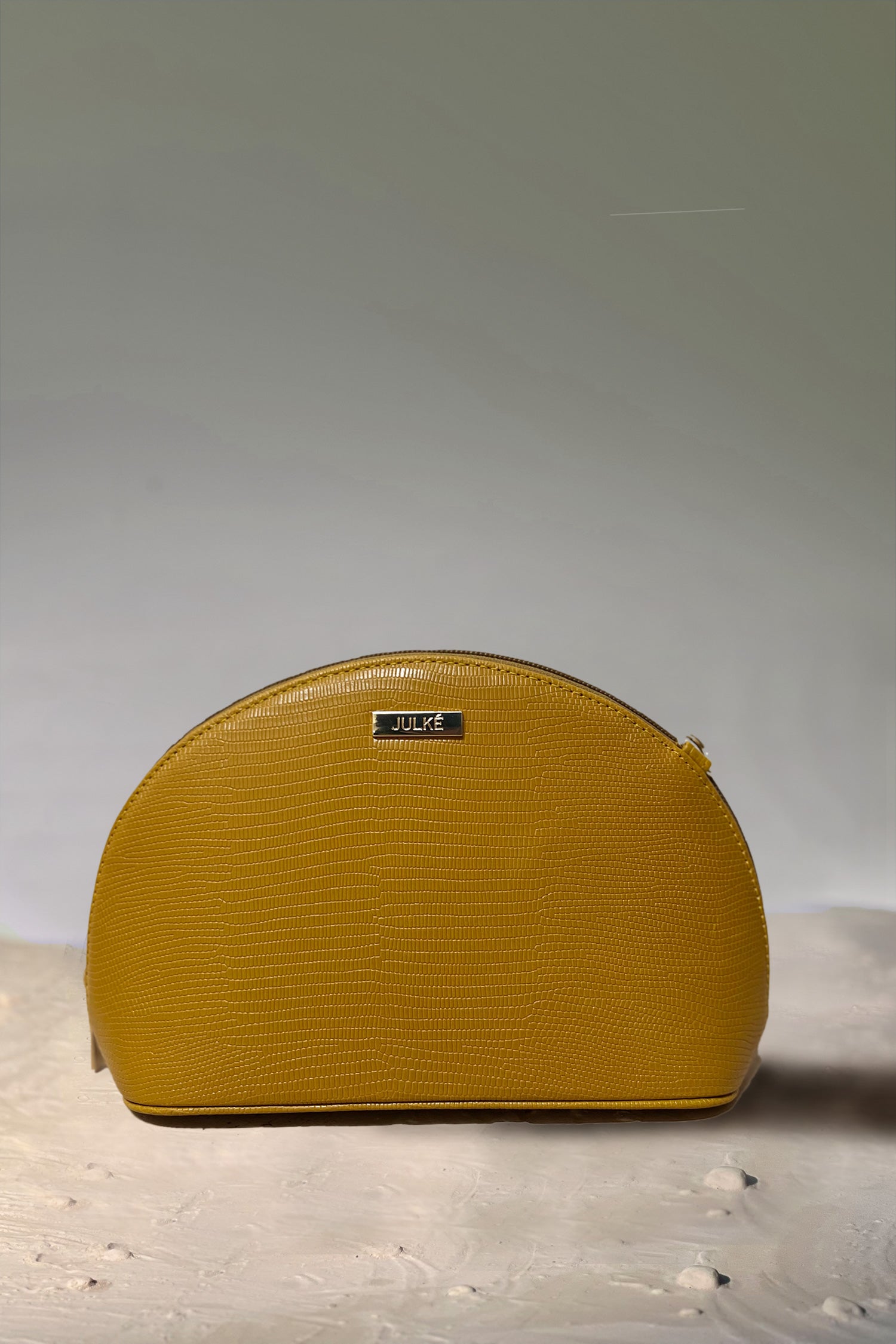 Women's leather travel makeup pouch in mustard yellow colour in semi-circle shape with detachable chain strap by JULKE