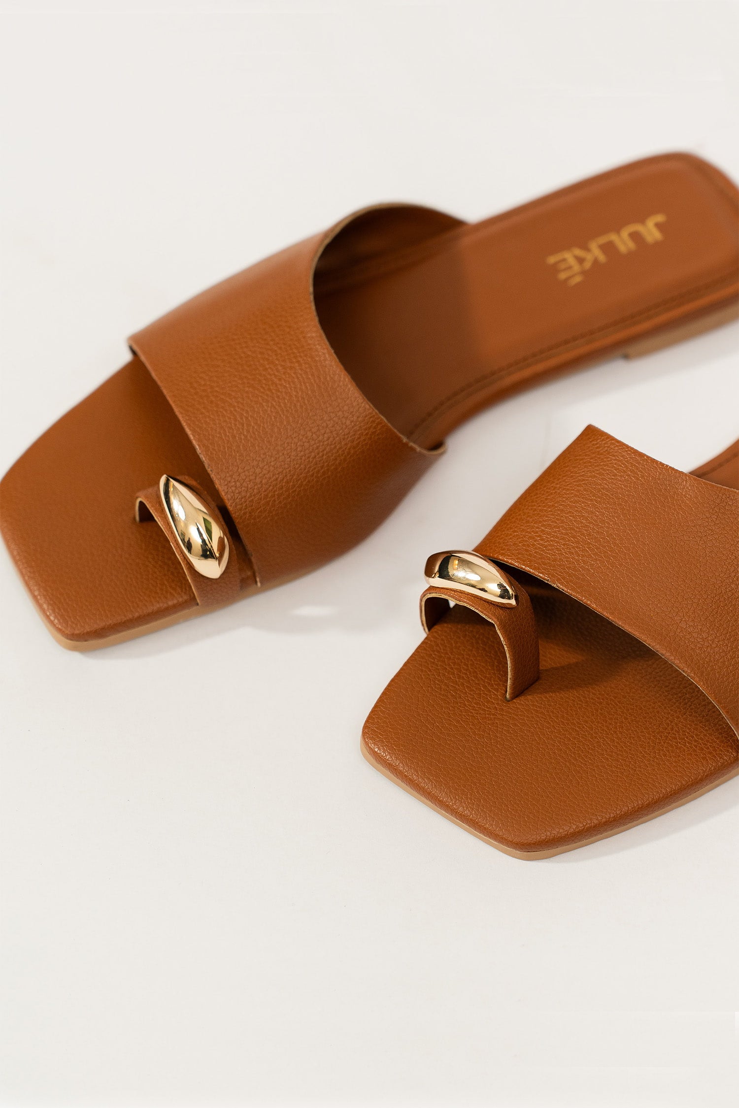 Womens flat slides in brown colour with toe strap and metallic golden toe ornament by JULKE. 