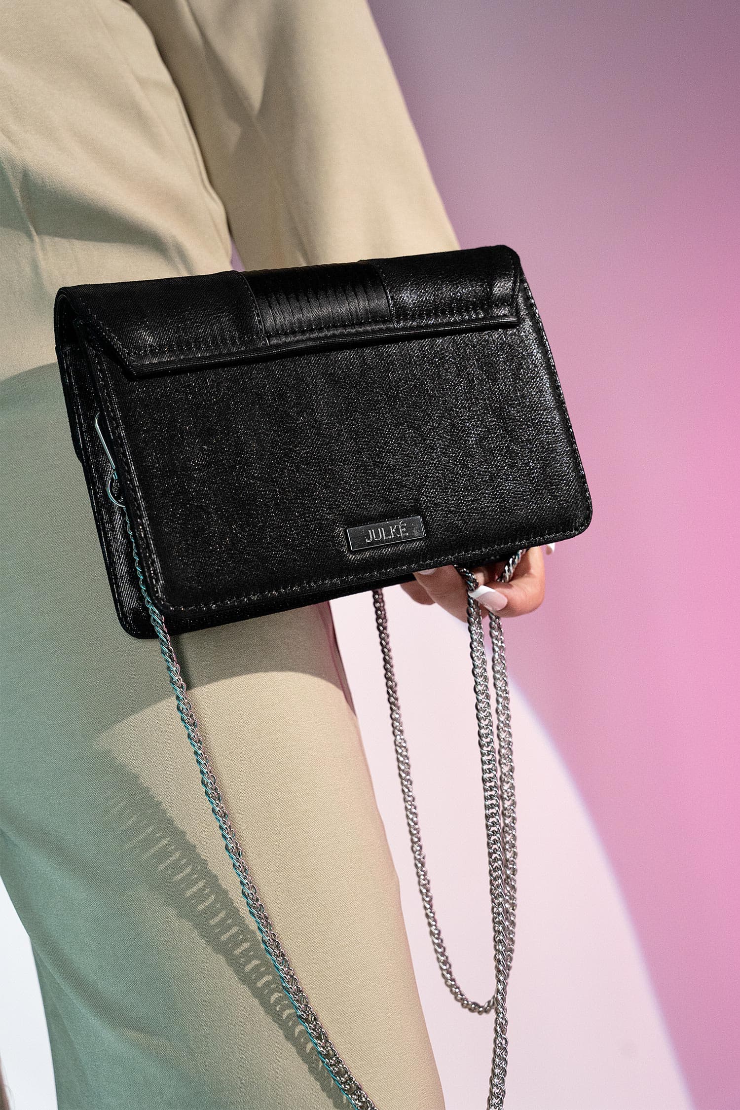 Women's suede leather clutch bag in shiny black colour with satin pleated flap and geometric transparent rhinestone brooch by JULKE.