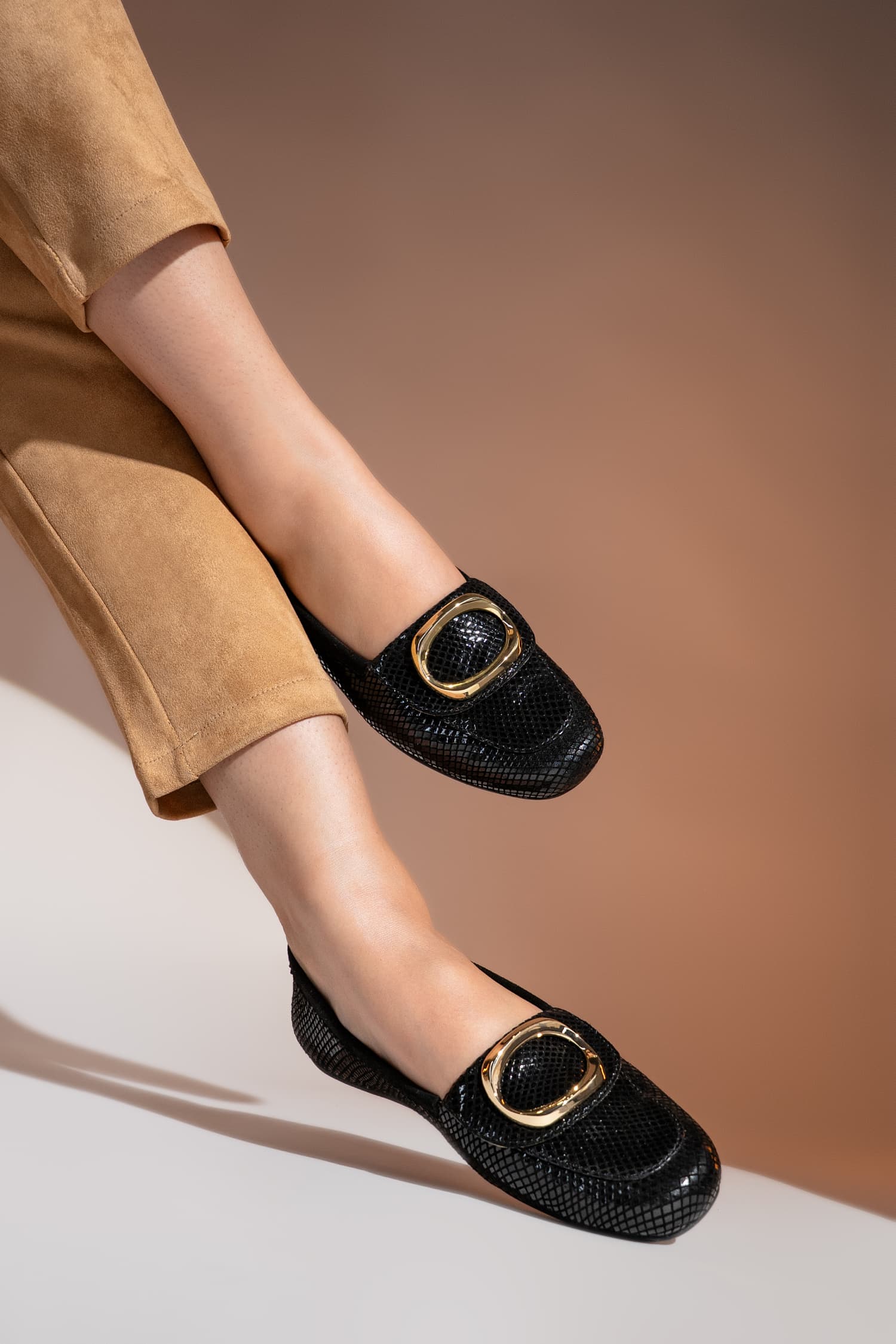 Womens textured leather loafers in black colour with large metallic gold round buckle by JULKE