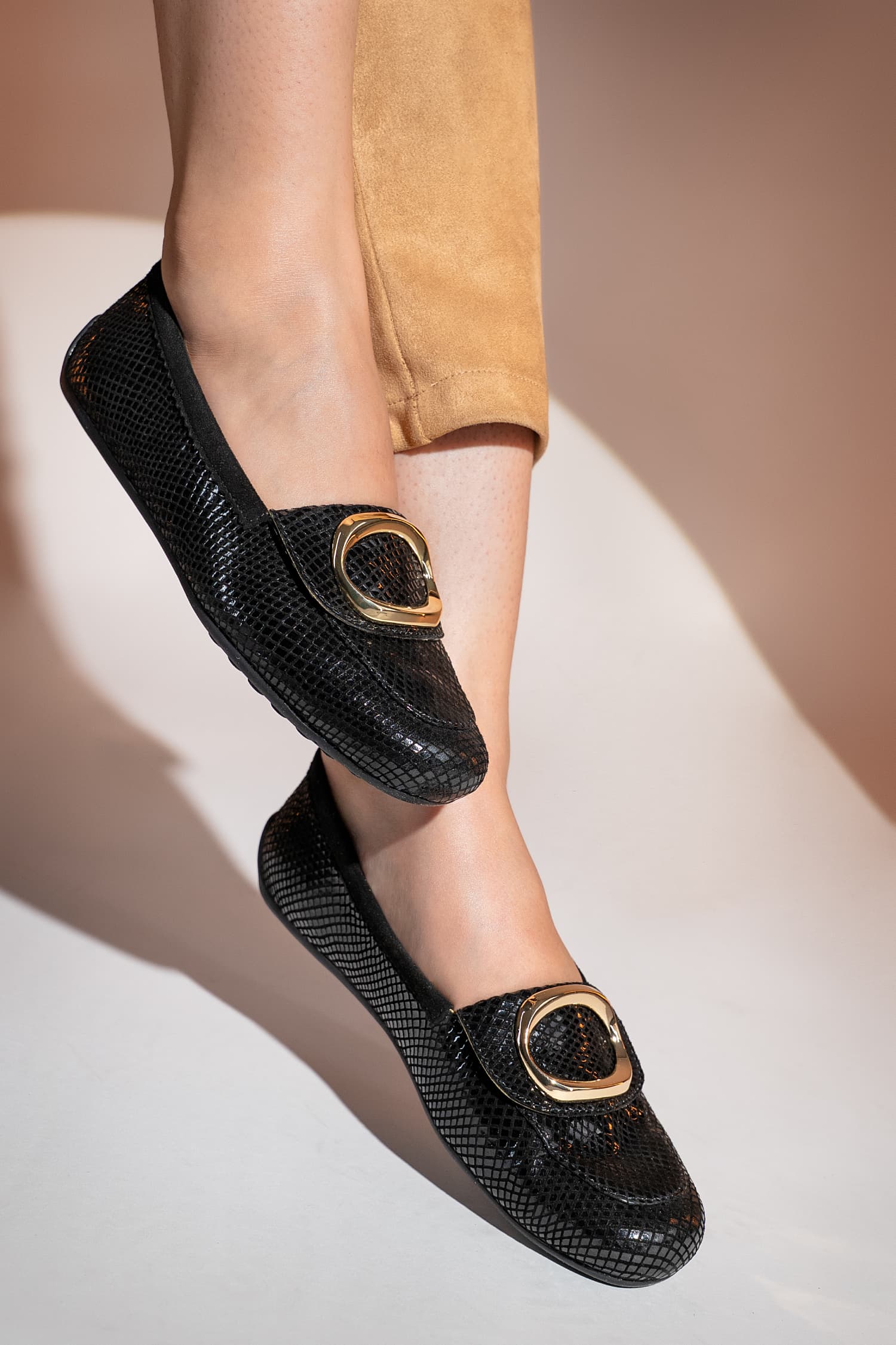 Womens textured leather loafers in black colour with large metallic gold round buckle by JULKE