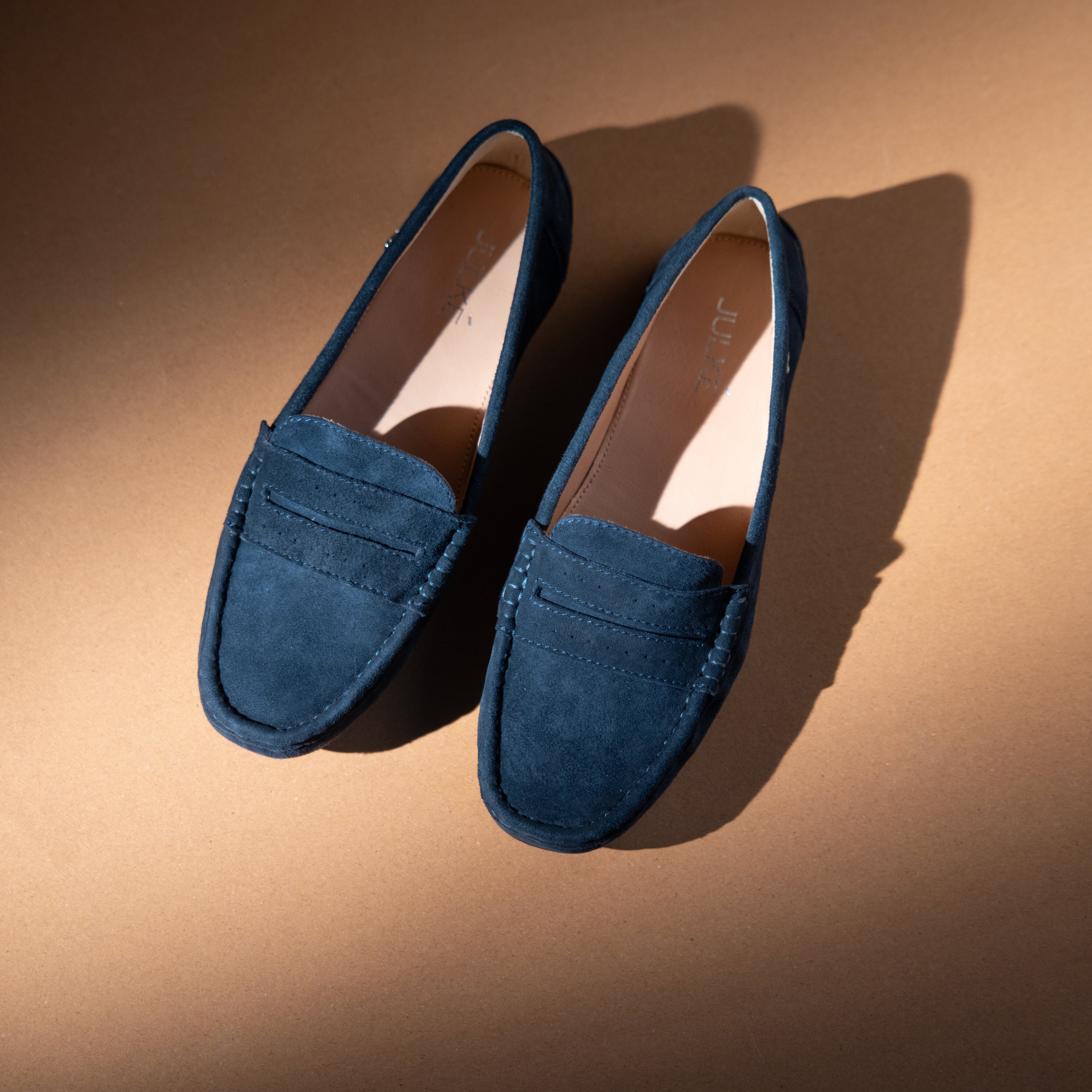 Women's winter suede leather moccasins in dark blue colour with metal logo trim and moc toe by JULKE 