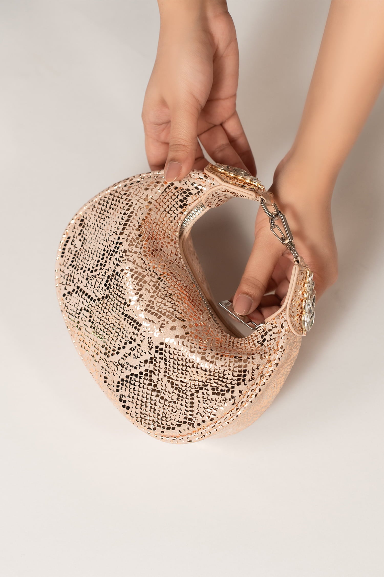 Women's leather mini halfmoon bag in light pink colour with 3d reptile texture and unique clip-on handle by JULKE.