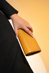 Women's leather long wallet in mustard yellow colour in envelope shape with long pockets and metallic horse-bit buckle and brand logo by JULKE. 