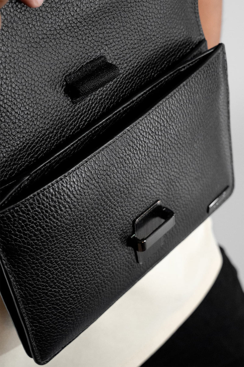 Unisex soft leather small travel crossbody bag in black colour with metal push lock spacious pockets and detachable wide strap by JULKE